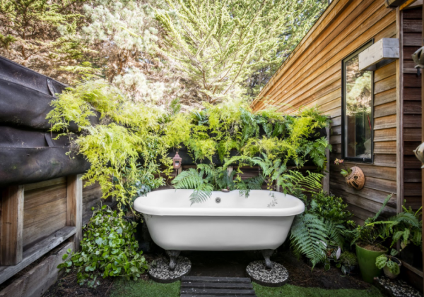 Kamar mandi dengan bathtub outdoor di taman belakang